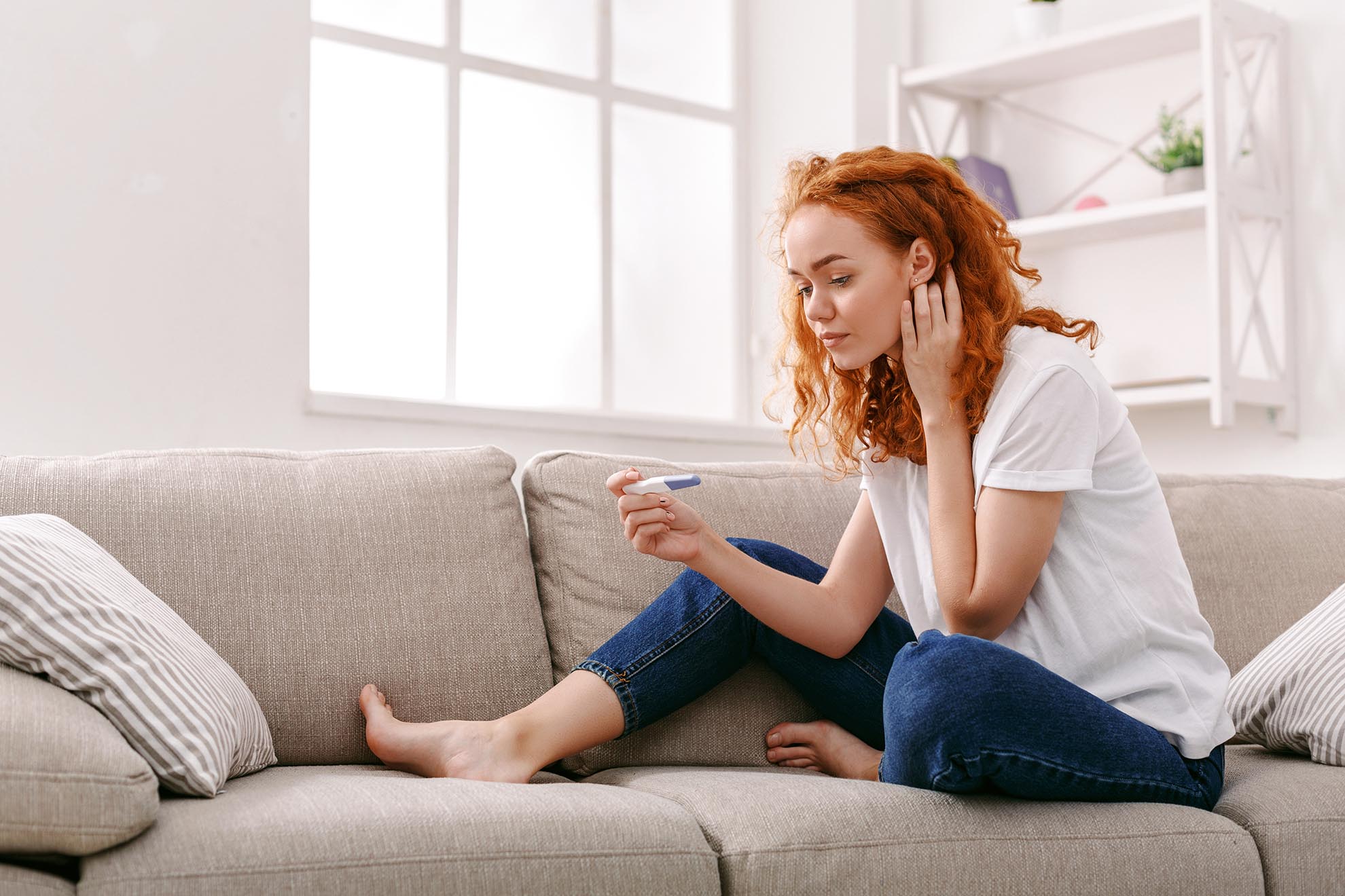 Worried girl reading the results of her pregnancy test